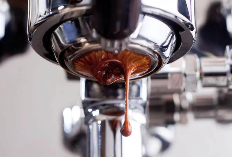 Espresso flowing from a naked portafilter